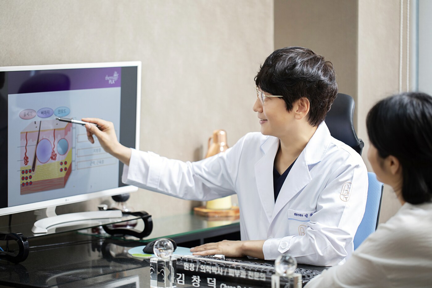 범어로제피부과 피부 구조 그림을 가리키며 설명하는 원장님 상담 장면